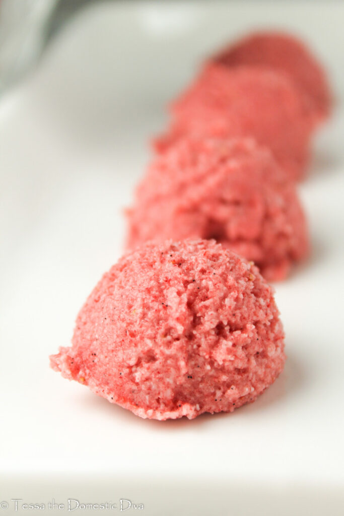 strawberry macaroons arranged on a white plate at eye level