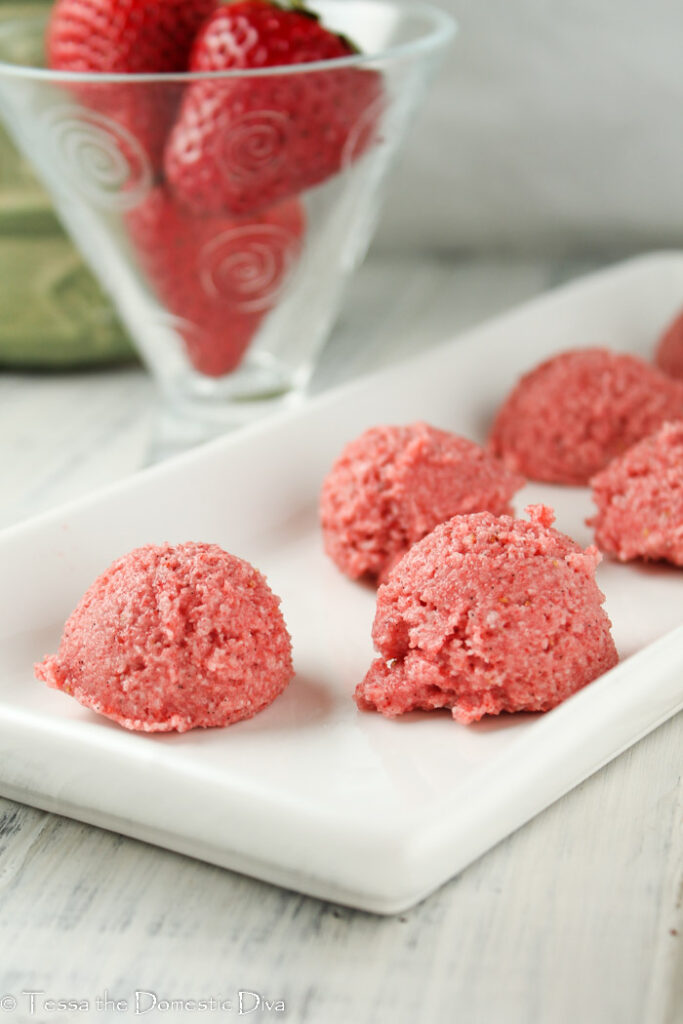 healthy strawberry macaroons on a white plate and white washed plank board