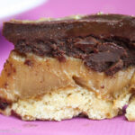 close up eye level view of a shortbread and creamy peanut butter cookie bar with a chocolate topping