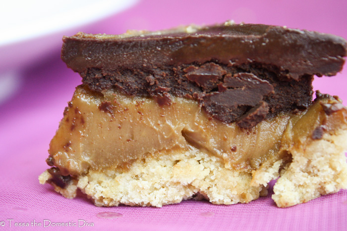 close up eye level view of a shortbread and creamy peanut butter cookie bar with a chocolate topping
