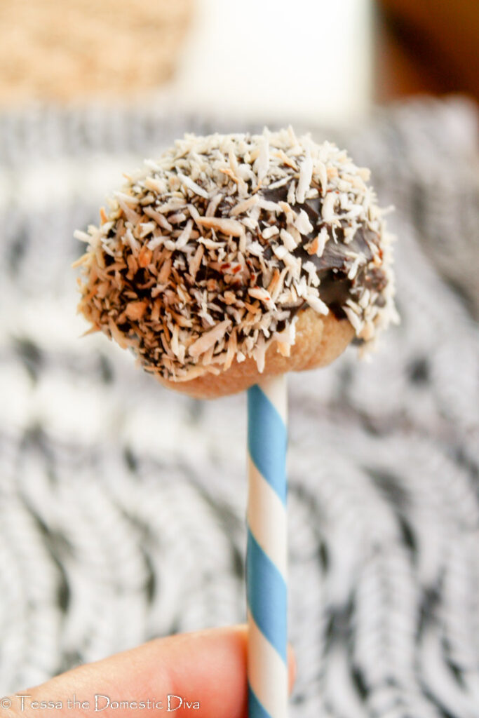 a handheld chococlate coated cookie dough pop