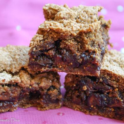 three squares of gluten free fig newtons on a sparkling purple cloth