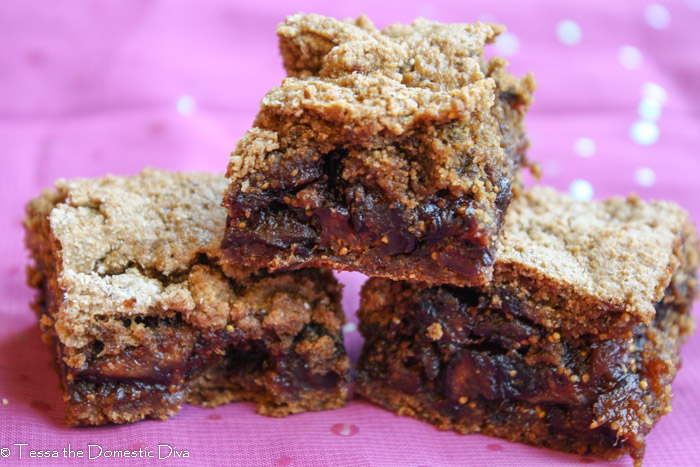 three squares of gluten free fig newtons on a sparkling purple cloth