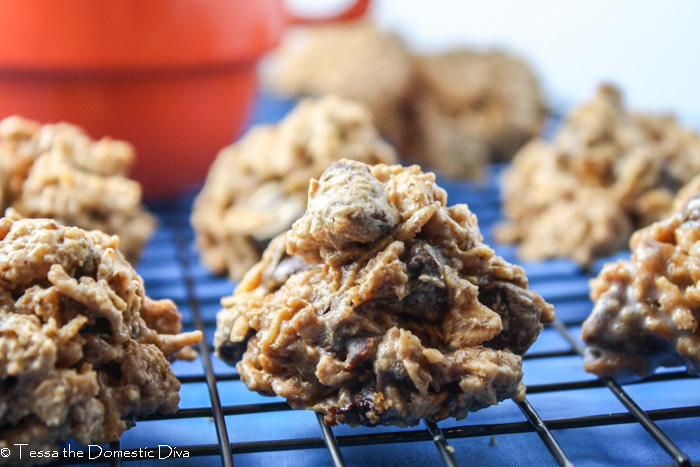 multiple chocolate chip oatmeal cookies on cooling rack atop a royal blue surface