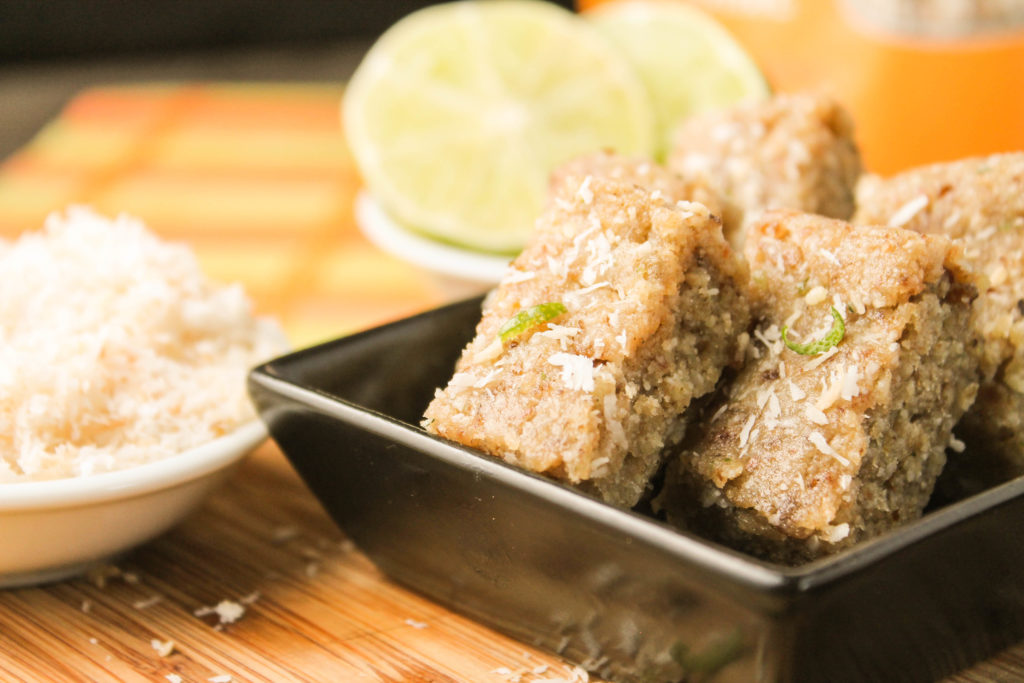 square black dish filled with compressed nut, coconut and lime bars. 