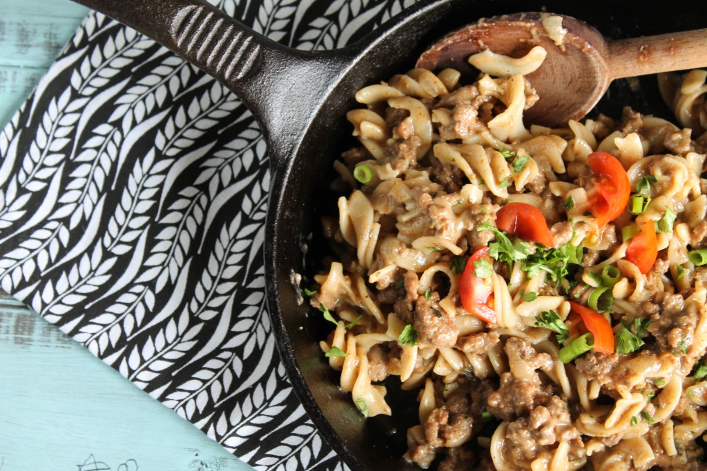 noodle hamburger skillet in cast iron pan with a garnish or parsley and red peppers from overhead