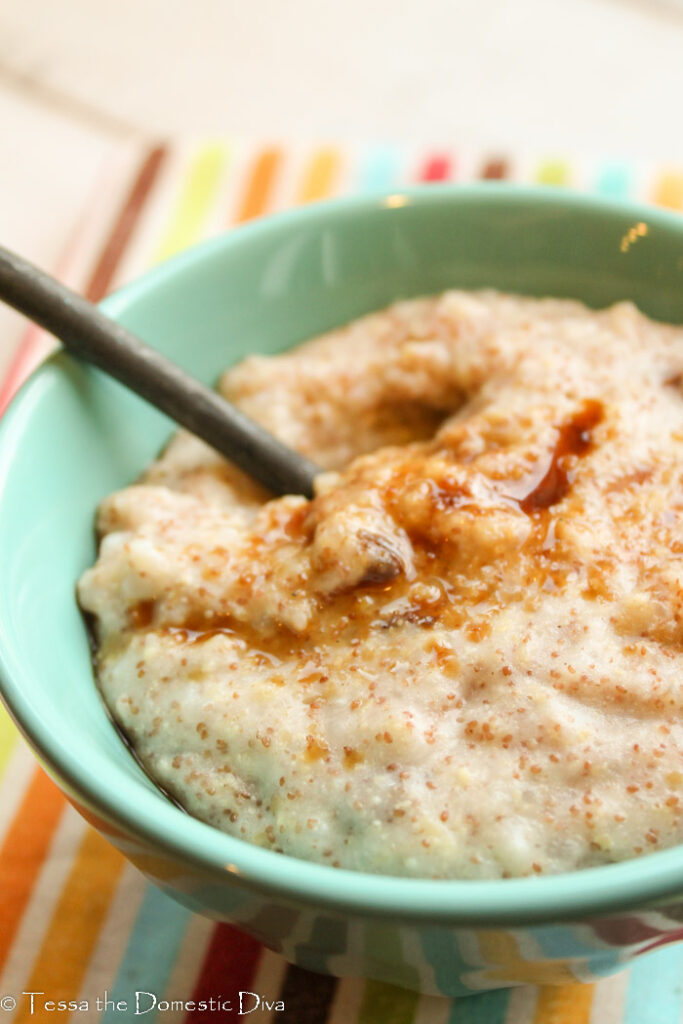 a turquoise bowl filled with brown rice, teff, and millet hot cereal with a cinnamon sprinkle