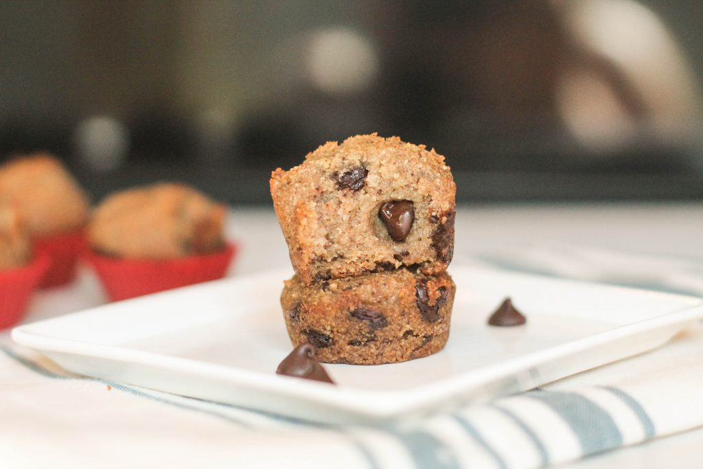 paleo banana bread muffins on a white plate with ooey gooey chocolate chips on a white square plate with a dark background