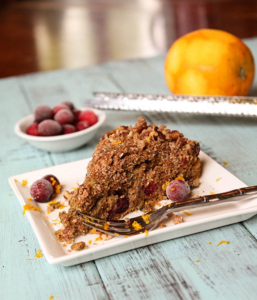 a slice of streusel topped coffee cake with cranberries and orange