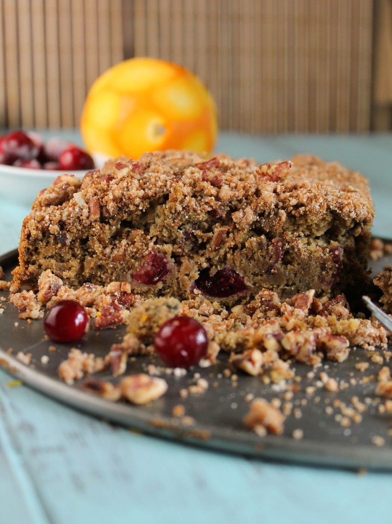 close up of a slice of cranberry studded coffee cake with a crumb topping