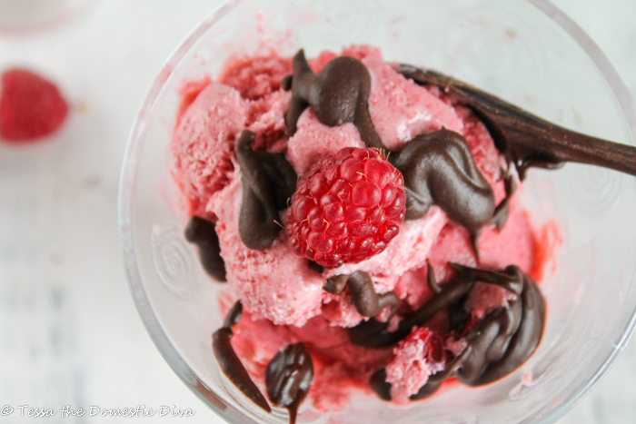 overhead shot of a clear glass cup with a vegan strawberry ice cream topped with homemade chocolate sauce