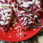 overhead view of cranberry cake with a triangle slice removed and another of a silver serving spatula
