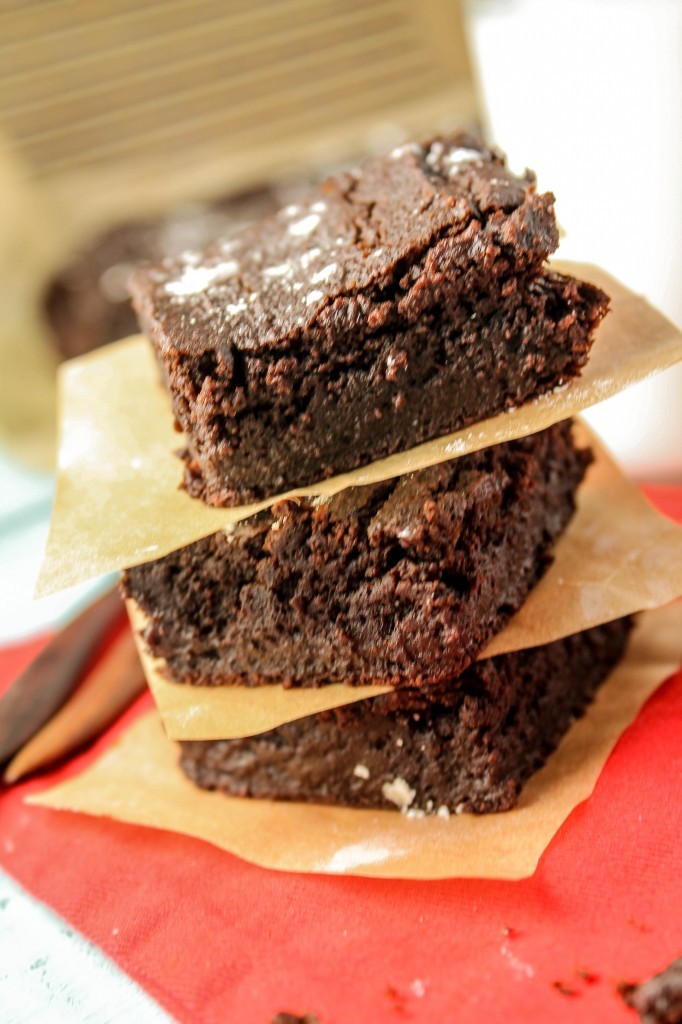 eye level three chocolate brownies stacked with natural parchment paper between each.