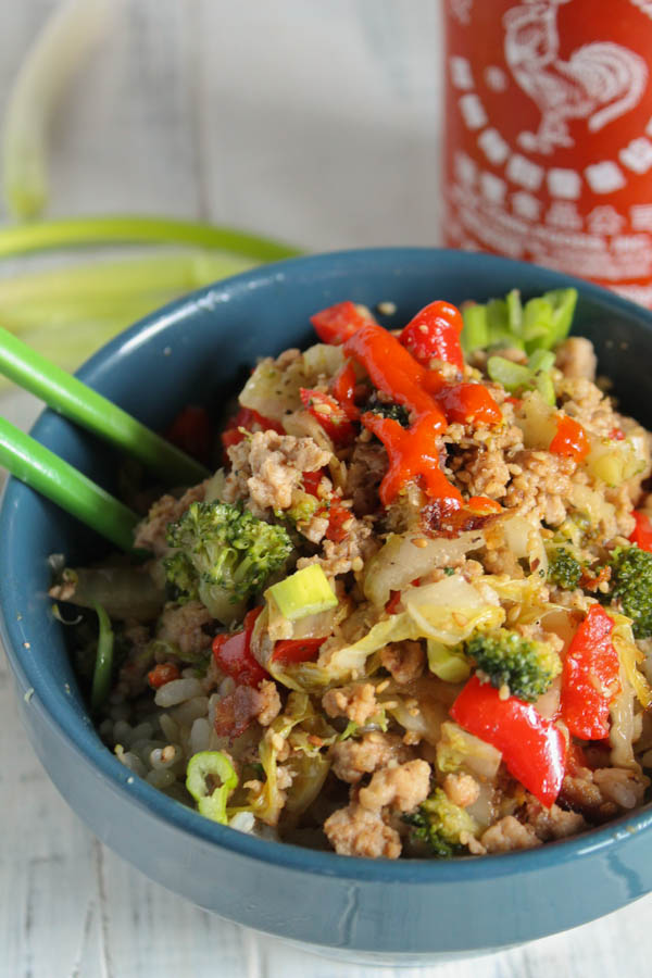 vertical image of a dusty blue bowl filled with ground meat with broccoli and red peppers
