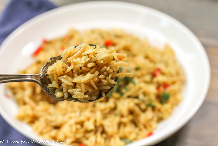a closeup of a spoonful of homemade chicekn rice a roni with a full bowl in the background