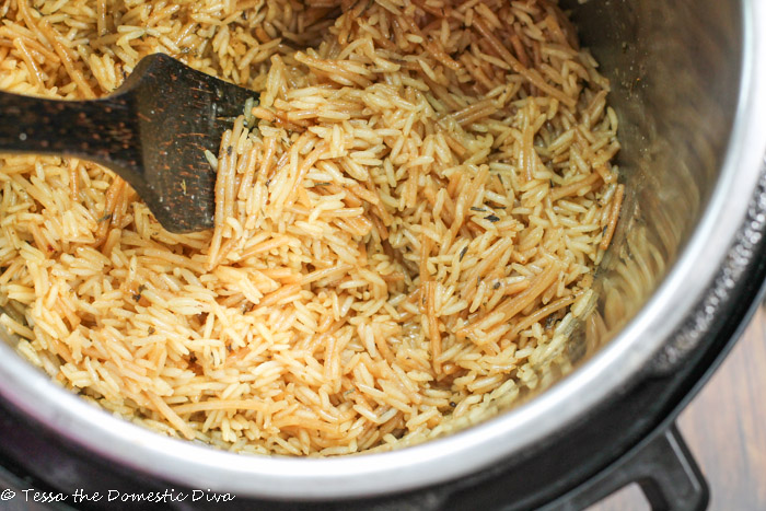 rice a roni cooked in an instant pot insert with a coconut wood serving spoon