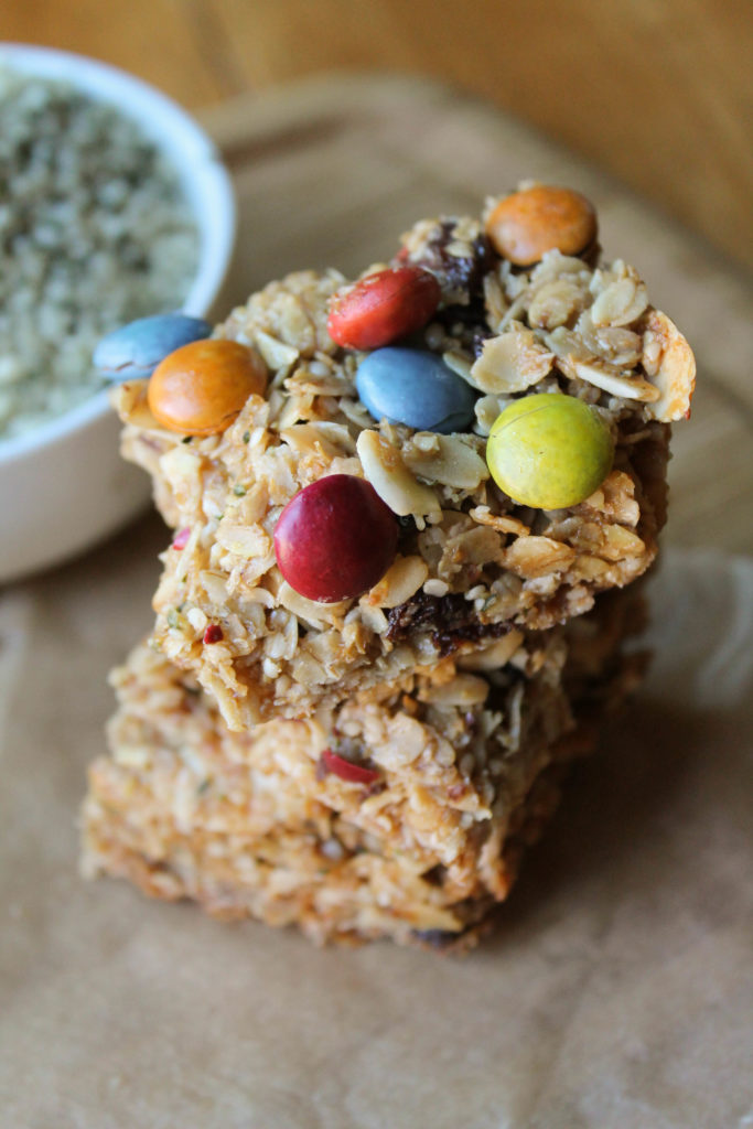 a stack of three homemade granola bars with natural dye chocolate candies.