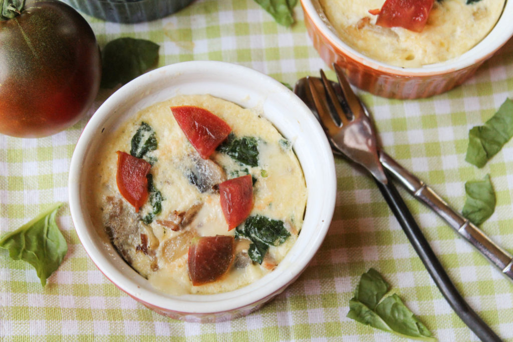 instant pot keto quiche from overhead on a lime checked cloth with tomatoes and spinach