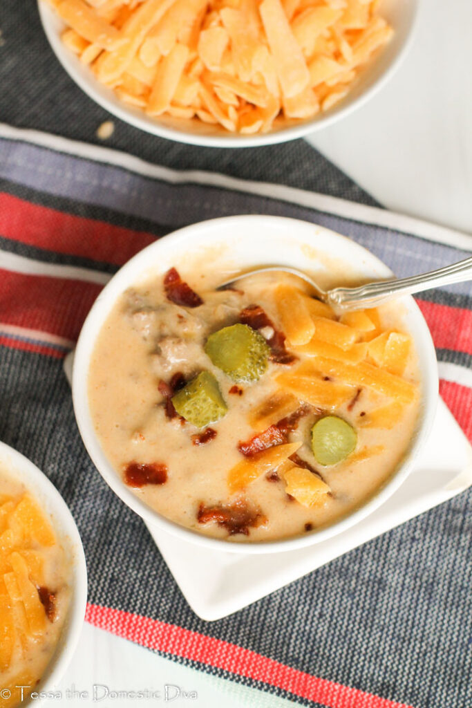 birds eye view of a white bowl filled with chunky ground beef and bacon in a cheesy broth.