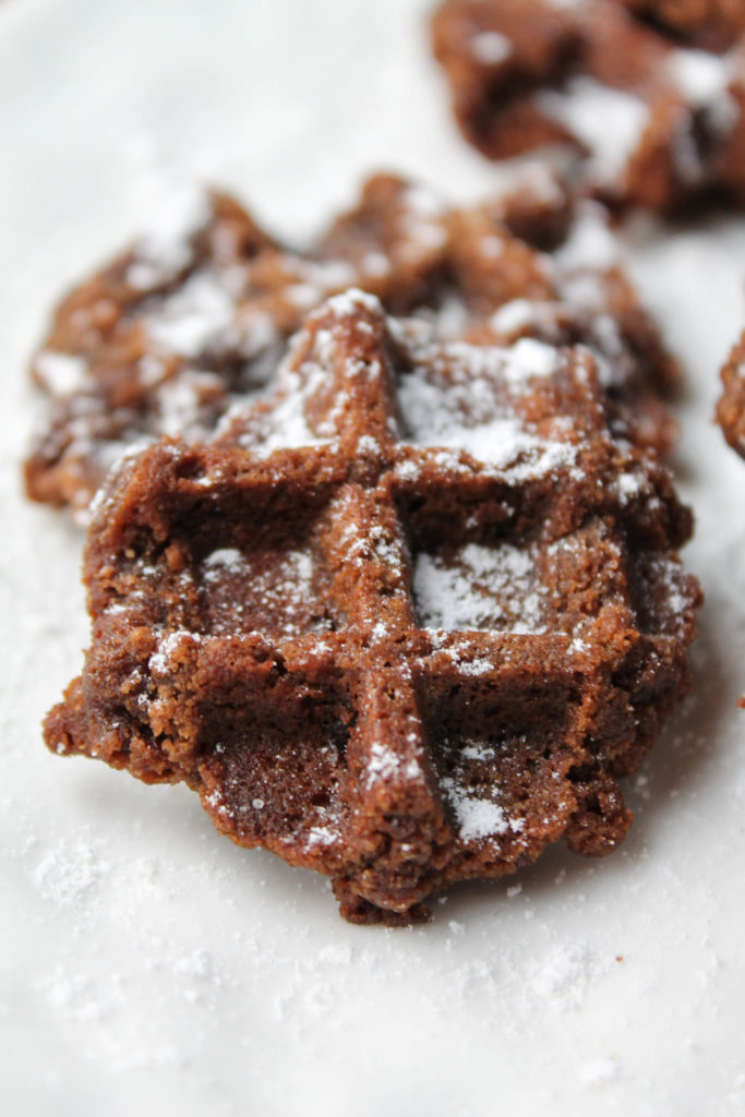 gluten free chocolate cookies baked in a waffle iron and dusted with powdered sugar