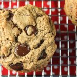 paleo chocolate chip cookie with chewy texture on a metal cooling rack and red with white polka dot background