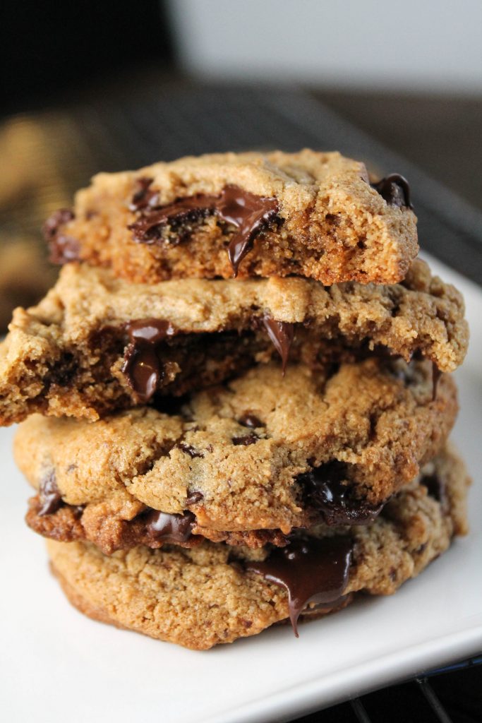 a stack of halved chocolate chip cookies with molten chips and golden edges