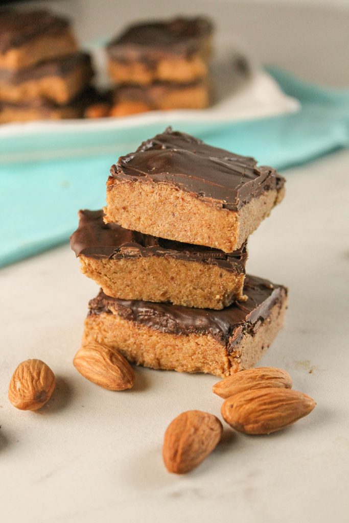 a stack of three almond butter and chocolate protein bars.