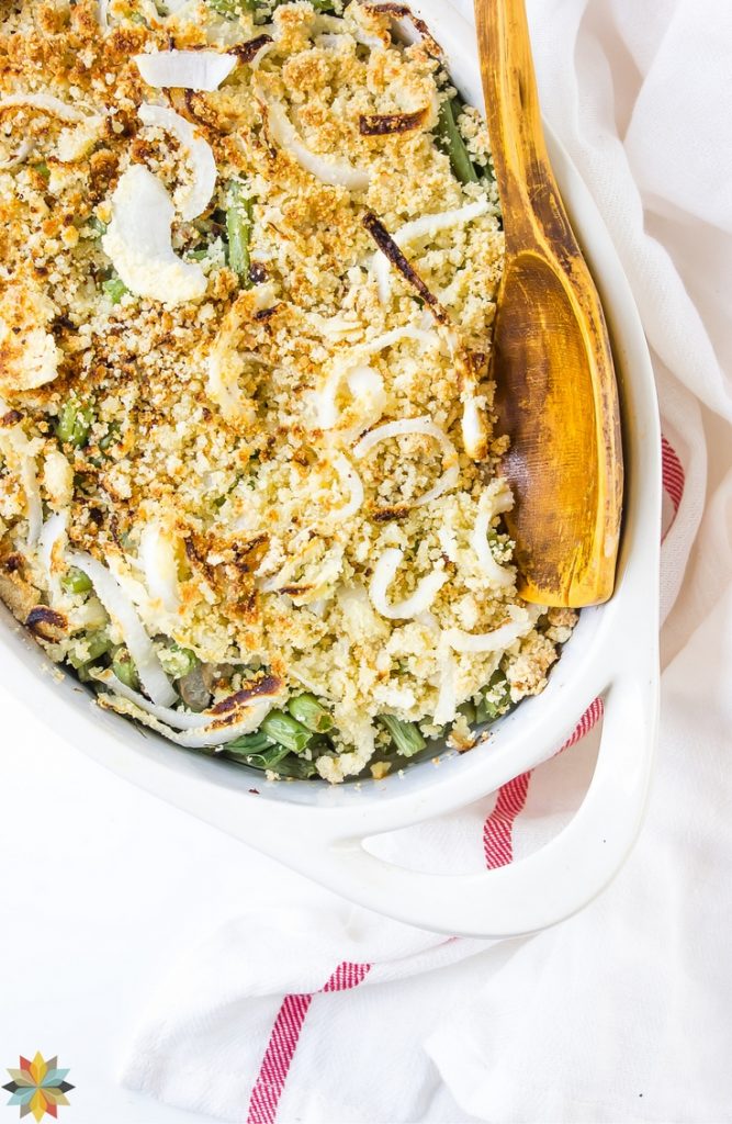 overhead shot of a white baking dish with handles filled with green beans and a crispy onion topping