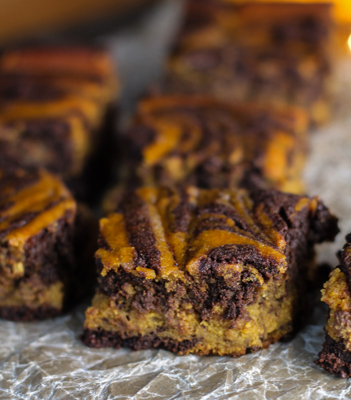 eye level close up of swirled pumpkin chocolate brownies on a piece of parchment paper
