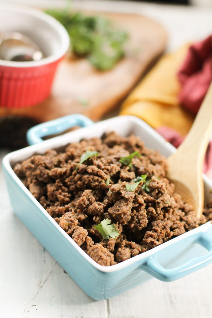 a blue square ceramic dish filled with taco ground beef and a cilantro garnish