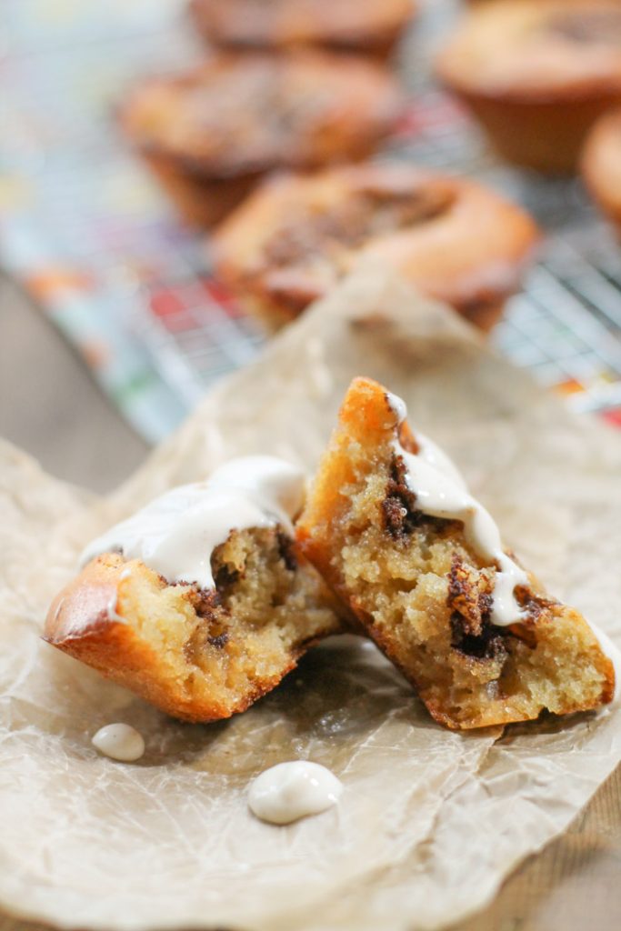 a cinnamon muffin torn in half and drizzled with white frosting