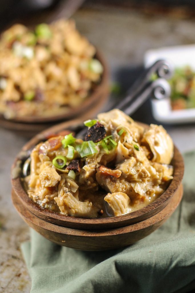 stacked wooden bowls filled with pulled chicken thighs in a creamy sauce with bacon