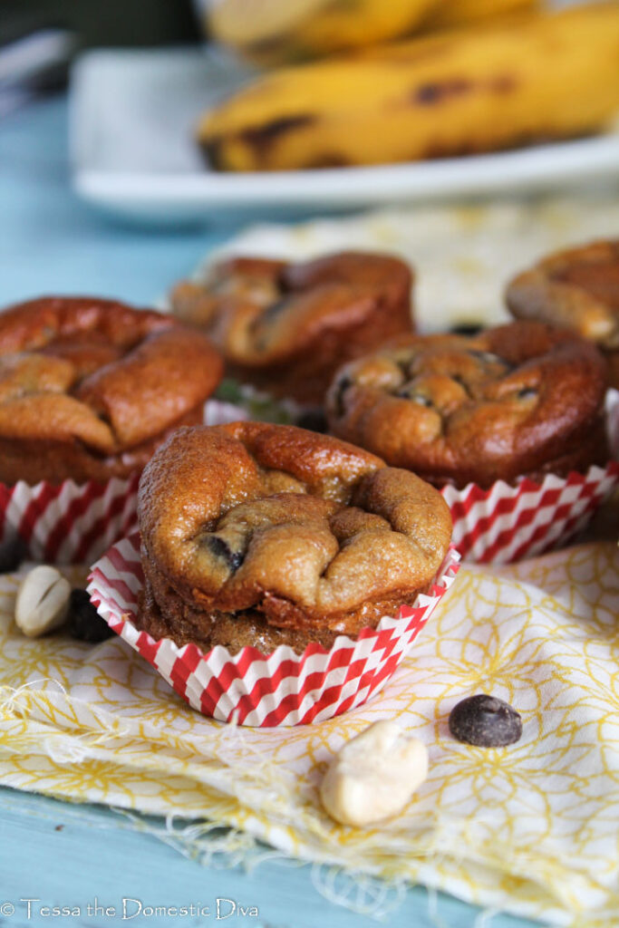 mini muffins with chocolate chips in white and red striped paper liners on a yellow cloth