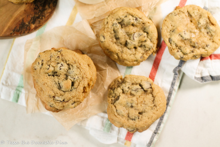 birds eye view of stacks of chewy chocolate chip cookes on a white a color striped linen