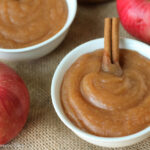 overhead view of two white bowls filled with homemade creamy applesauce