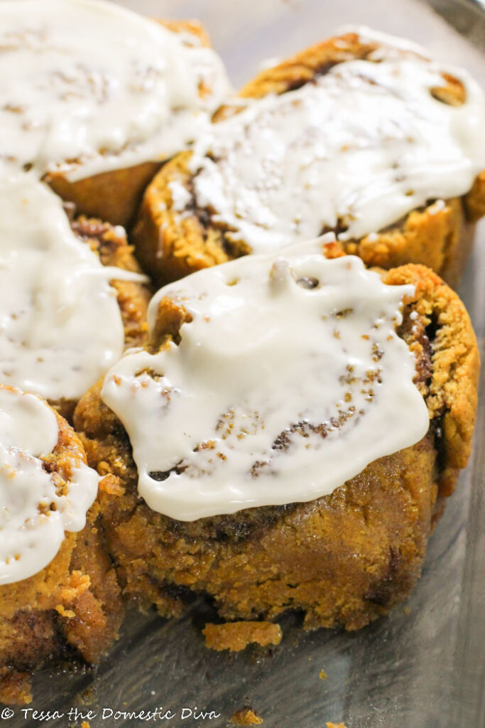 cream cheese glazed pumpkincinnamon rolls in a glass baking pan