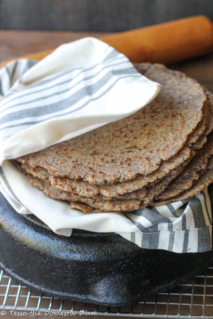 eye level stack of homemade tortillas with a rolling pin in the background