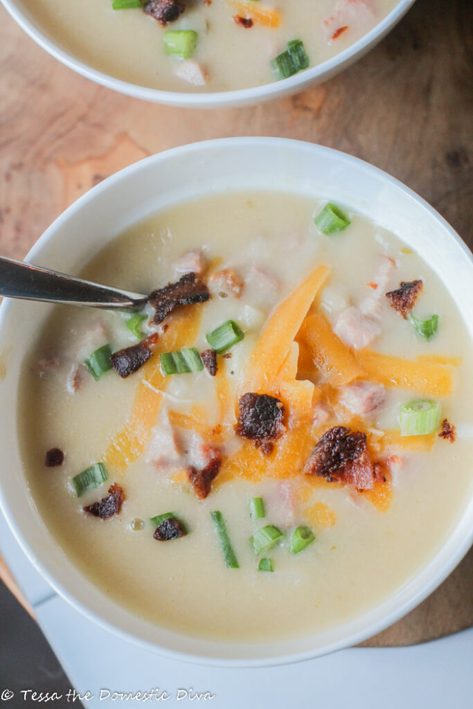 birds eye view of a white bowl filled with ham and potato soup