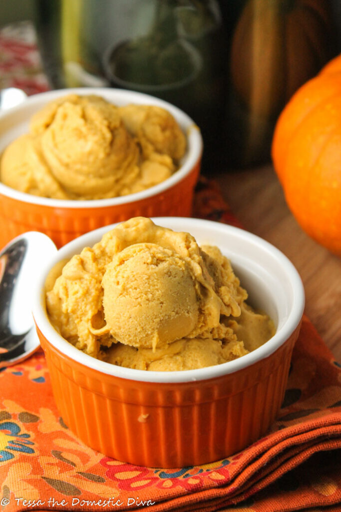 two pumpkin orange ramekins with scoops of orange hued pumpkin ice cream 