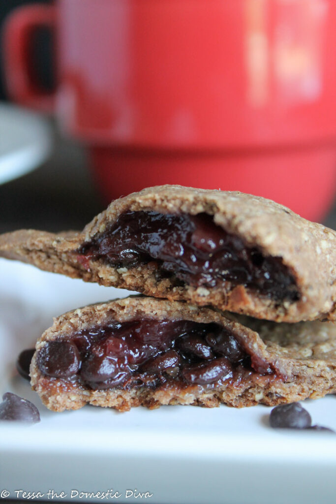 empanadas cut in half and filled with jelly and dark chocolate on a white plate