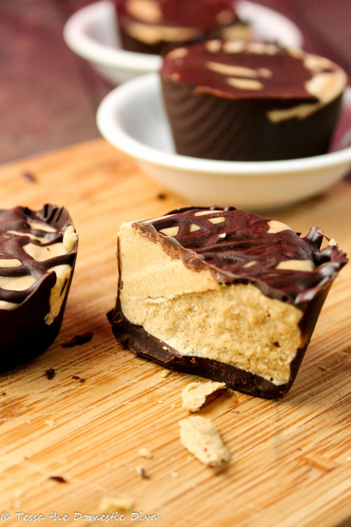 a halved homemade healthy peanut butter cup on a bamboo cutting board