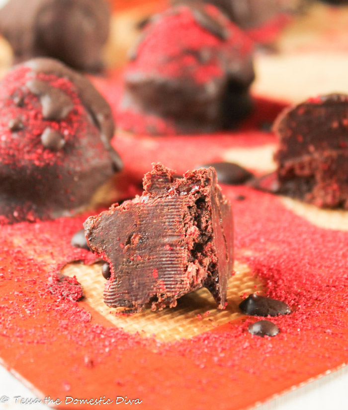 dark chocolate truffles dusted with raspberry powder on a silicon baking mat