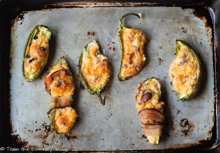 birds eye view of six Jalapeño Poppers wrapped in bacon on an aged cookie sheet