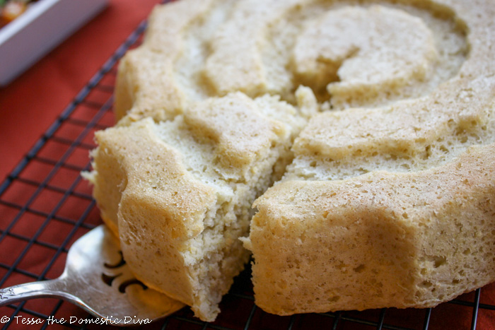 a slice of cornbread on a srver being removed froma round cornbread slab