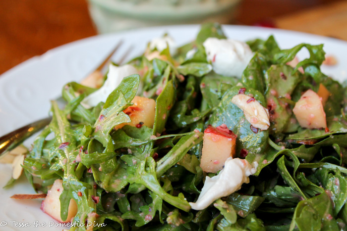 close up of mixed greens drssed in a bright red cranberry