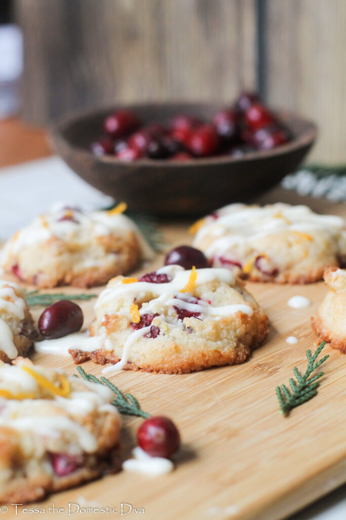 eye level view of fresh cranberry studded cookies with orange zest and cedar boughs