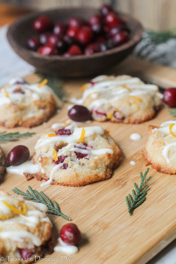 fresh cranberry cookies with a drizzle of orange cream cheese glaze and fresh orange zest scattered on top