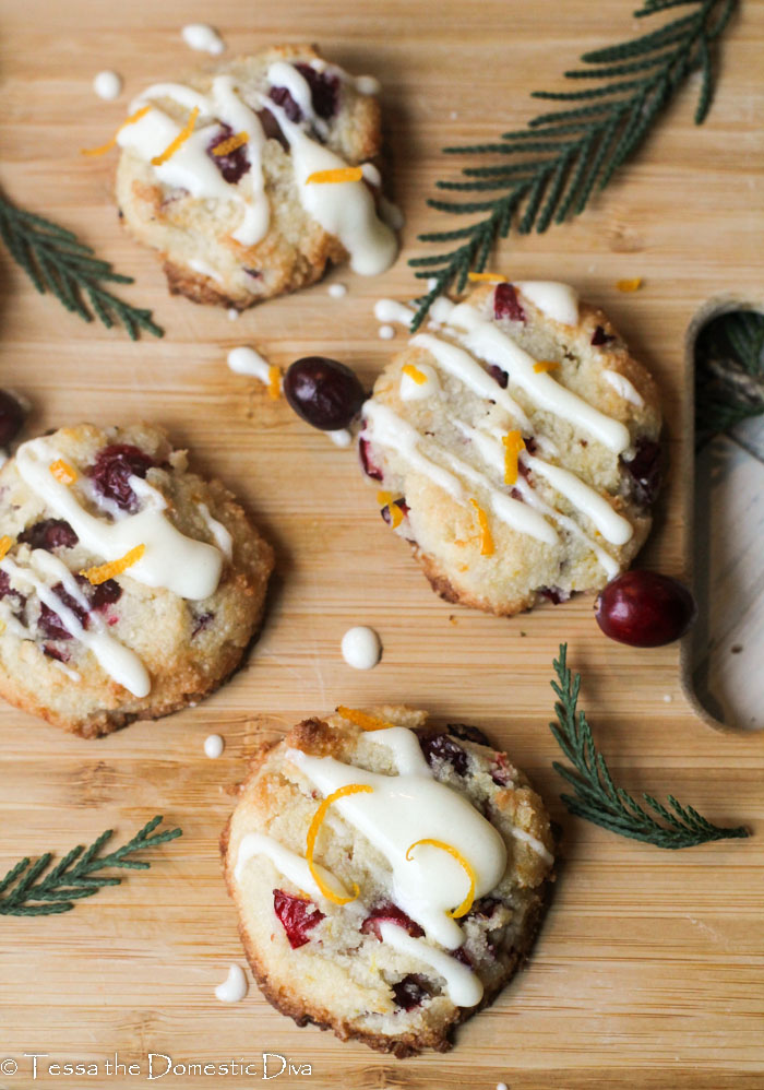 birds eye view of cranberry orange cookies with a cream cheese glaze and evergreen boughs about