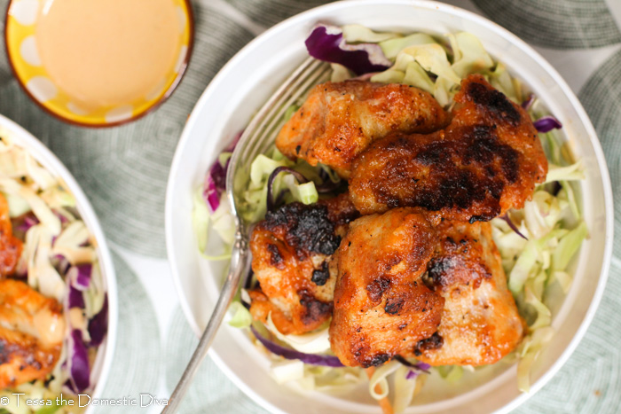 birds eye view of a white bowl filled with a creamy Cajun coleslaw with cripsy pan fried chicken breast bites