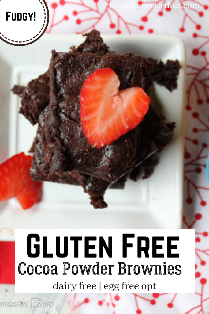 pinterest ready overhead view of a stack of fudgy cocoa powder brownies topped with a heart shaped sliced strawberry